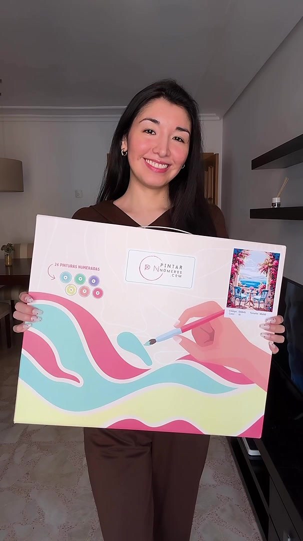 Clienta sonriendo con su caja de Pintar Números recién recibida