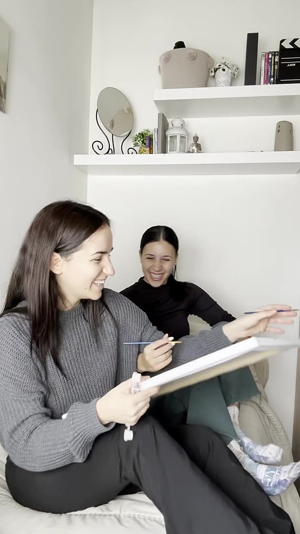 Dos amigas pintando juntas en el sofá
