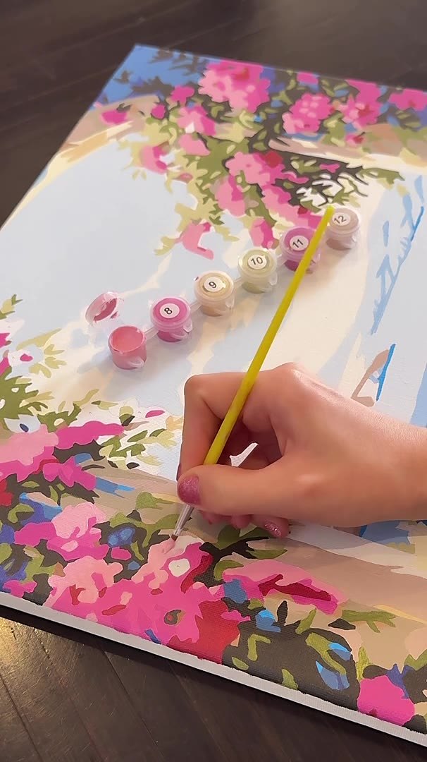 Mano pintando flores rosas en el lienzo